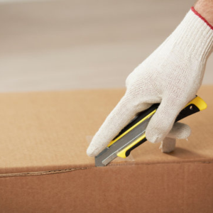 A cardboard box being opened using a retractable packing knife